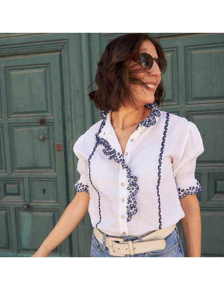 Short-sleeve white lace blouse, front view, green door in the background - MONPIEL