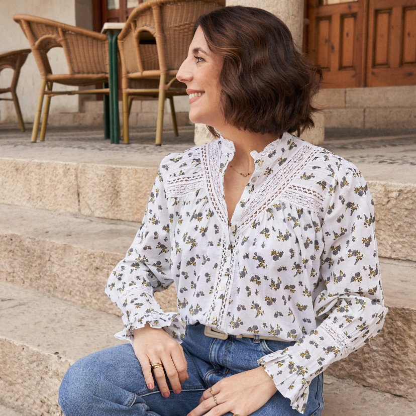 Long-sleeve lace blouse with blue floral pattern, medium shot, front view, seated on stairs - MONPIEL