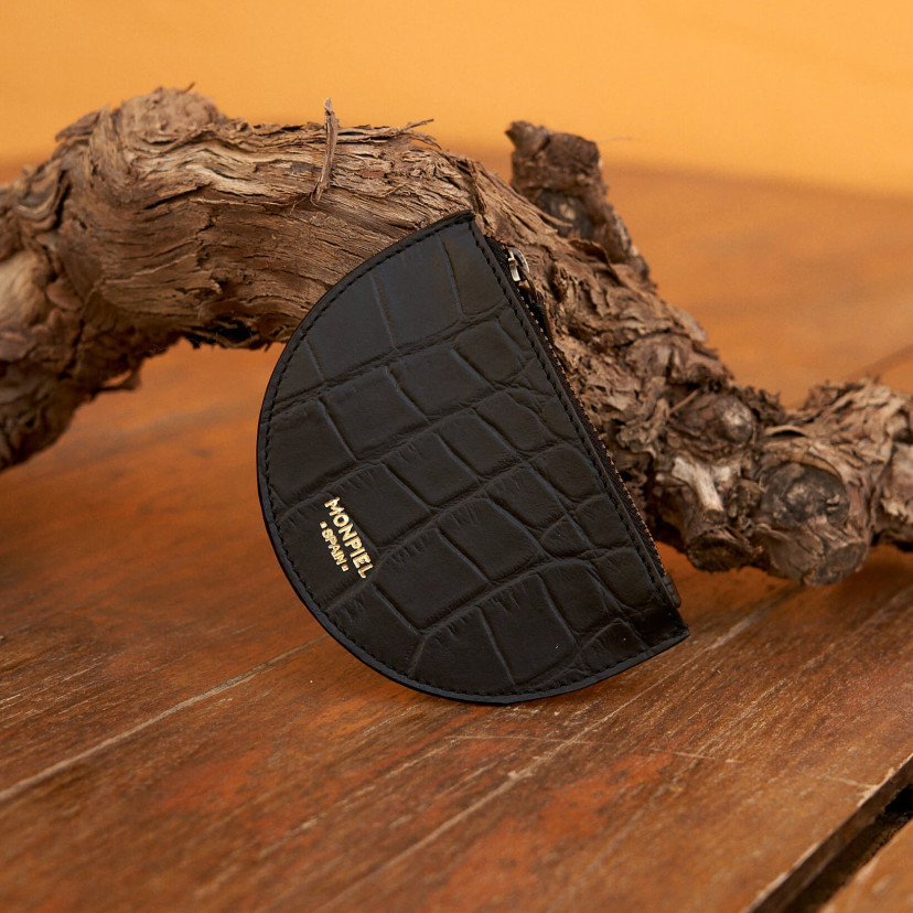 Half-moon leather coin purse in black color, resting on a branch - MONPIEL