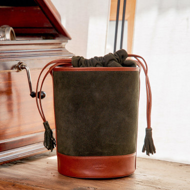 Sac rond en cuir noir façon seau, vue de face, avec fond mur - MONPIEL 2