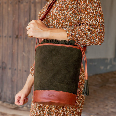 Sac rond en cuir noir façon seau, vue de face, avec fond mur - MONPIEL 2