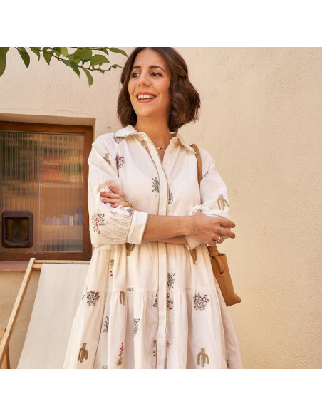 Handbesticktes Kaktus-Kleid in Knochenfarbe, Frontalansicht im Freien, verschränkte Arme - MONPIEL Handbesticktes Kaktus-Kleid in Knochenfarbe, Frontalansicht im Freien, verschränkte Arme - MONPIEL