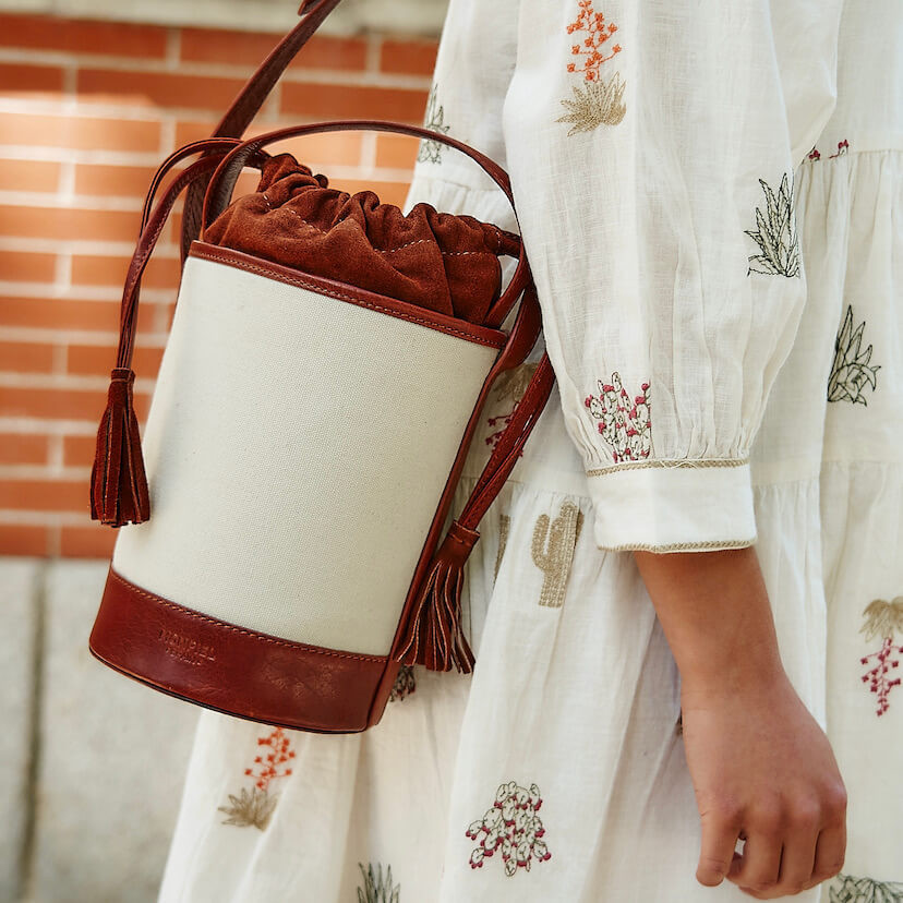 Bolsa cubo pequena de canvas em tom couro pendurada no ombro - MONPIEL