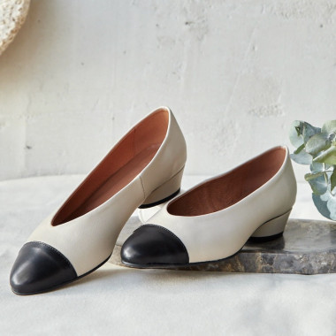 Ballerine à talon et bout bicolore en cuir beige, vue en perspective, posées sur du marbre - MONPIEL 2