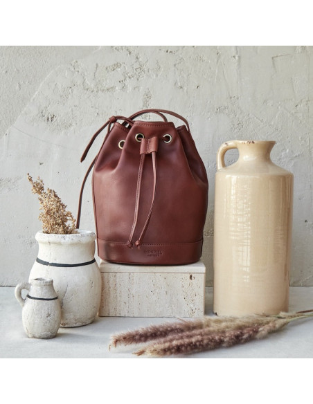 Grand sac seau en cuir couleur cuir, vue de face, à côté de vases - MONPIEL