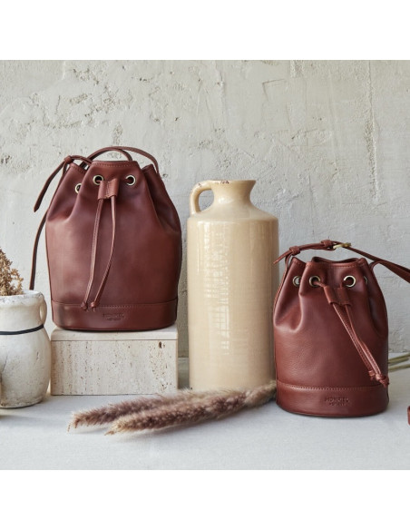 Grand sac seau en cuir couleur cuir, vue de face, avec un petit sac et un vase au milieu - MONPIEL