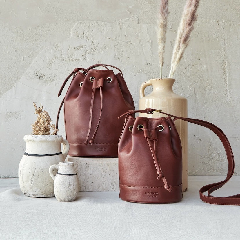 Large leather bucket bag in tan color, with a small bag beside it - MONPIEL