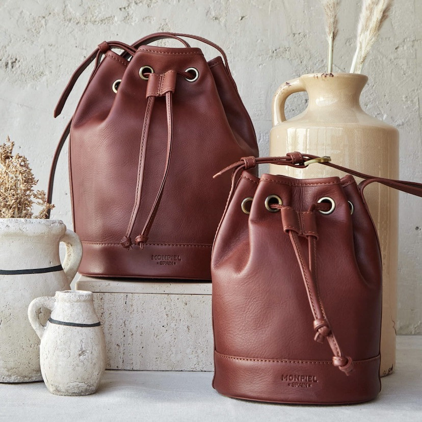 Large leather bucket bag in tan color, small bag beside it, close-up - MONPIEL