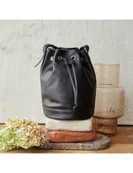 Borsa secchiello grande in pelle nera, vista frontale, davanti a un vaso - MONPIEL