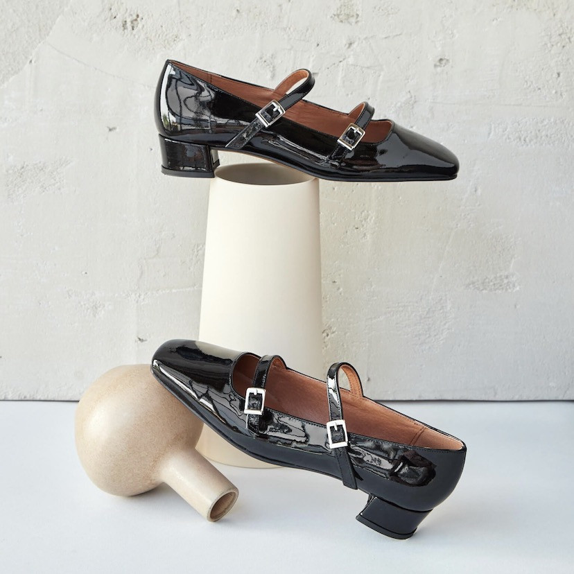 Lolina patent leather Mary Janes in black color, side and angled views, resting on a vase - MONPIEL