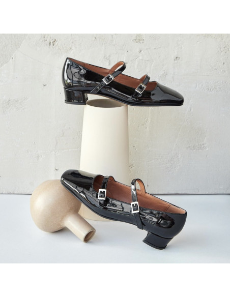 Glossy black patent leather Mary Jane shoes, side and perspective views, resting on a vase - MONPIEL
