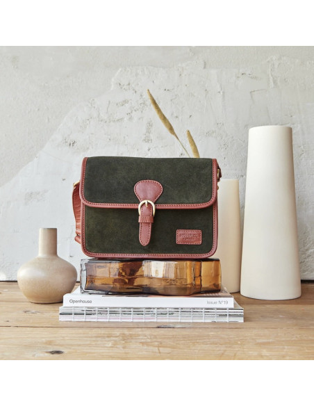 Sac satchel en cuir fendu vert avec boucle, vue de face, posé sur des livres - MONPIEL Sac satchel en cuir fendu vert avec boucle, vue de face, posé sur des livres - MONPIEL