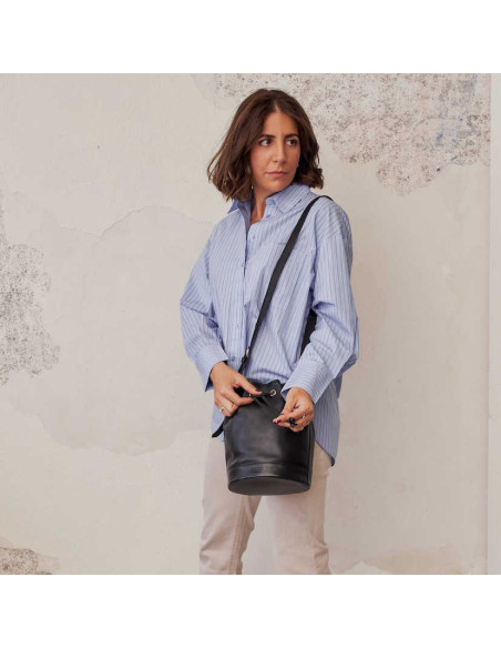 Bolsa bombonera grande de couro em preto, pendurada ao ombro, detalhe do fecho - MONPIEL