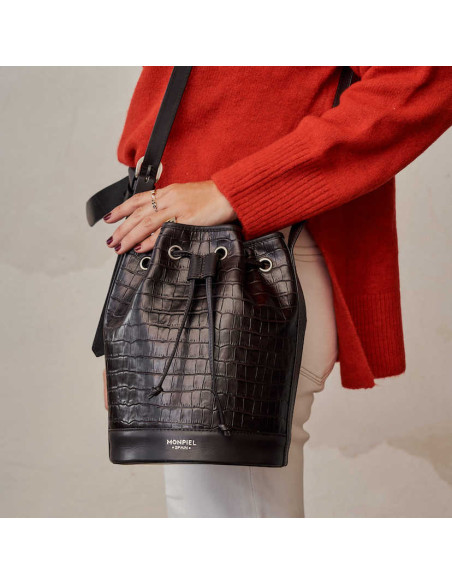 Borsa a secchiello grande in pelle marrone cocco, vista frontale, portata a spalla, con una mano appoggiata sopra - MONPIEL