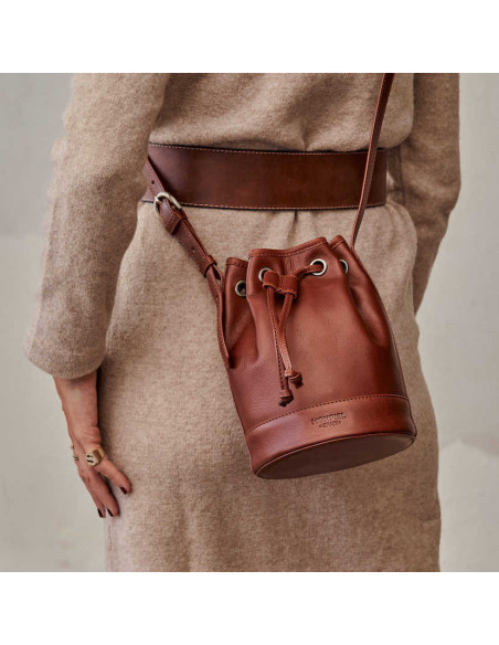 Kleiner brauner Leder-Bombonera-Beutel, als Crossbody am Rücken getragen - MONPIEL