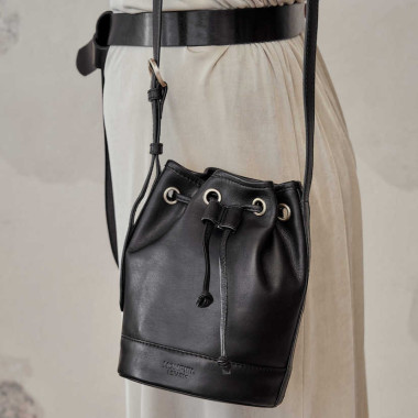 Kleine Ledertasche in Beutelform, Lederton, Frontalansicht, neben einer Vase - MONPIEL 2