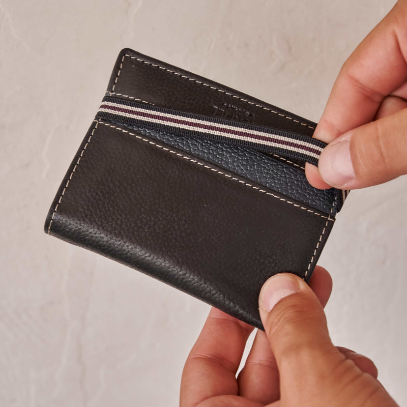 Black leather wallet with coin purse and rubber detail, close-up view - MONPIEL