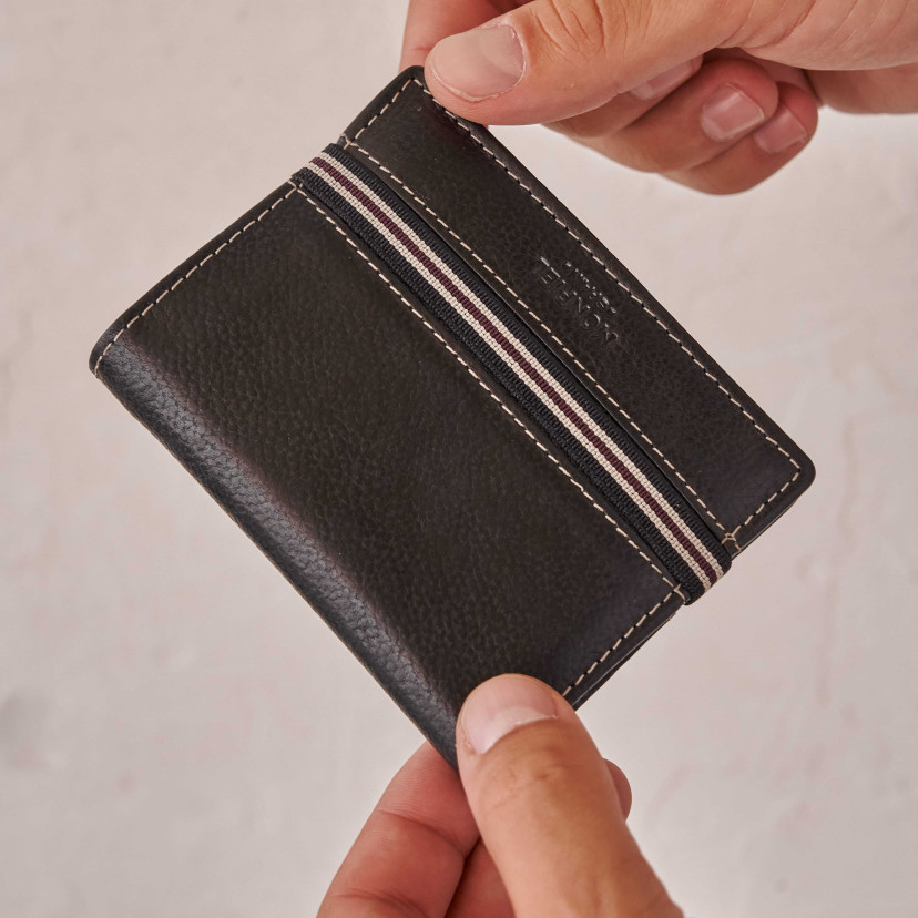 Black leather wallet with coin purse and rubber detail, held with fingers - MONPIEL