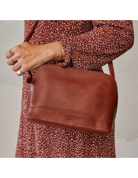 Borsa media in pelle color cuoio, portata a spalla con un vestito - MONPIEL