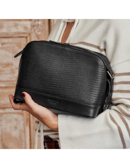 Bolsa média de couro preta com estampa de cobra, vista frontal, apoiada no braço - MONPIEL Bolsa média de couro preta com estampa de cobra, vista frontal, apoiada no braço - MONPIEL