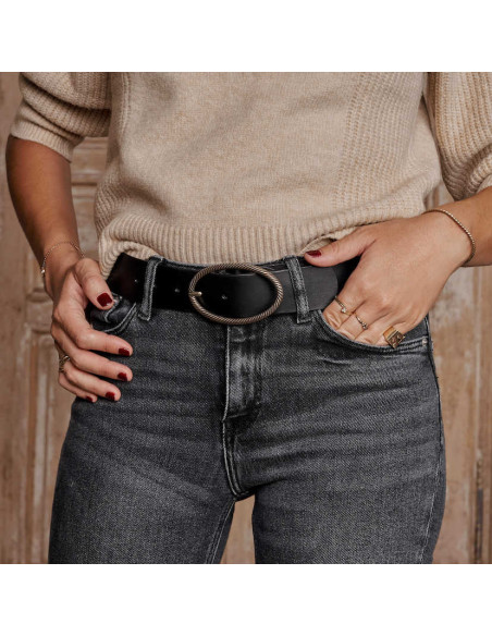 Black leather belt with an oval buckle, front view, worn on jeans - MONPIEL