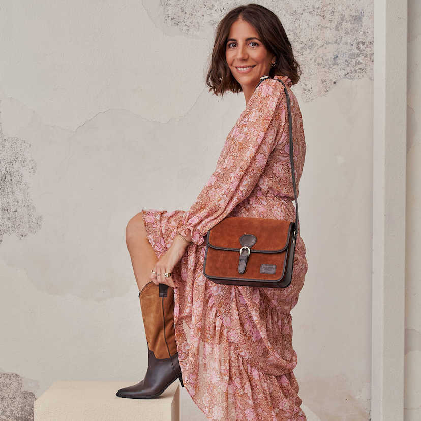Bolsa satchel em camurça marrom com fivela, pendurada ao ombro, plano geral - MONPIEL