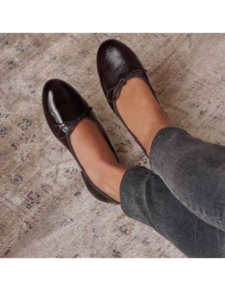 High vamp brown patent leather ballerina flats, crossed feet on a rug - MONPIEL