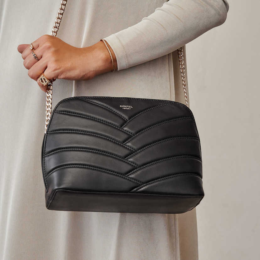 Black quilted leather bag with gold chain, hanging from the shoulder - MONPIEL