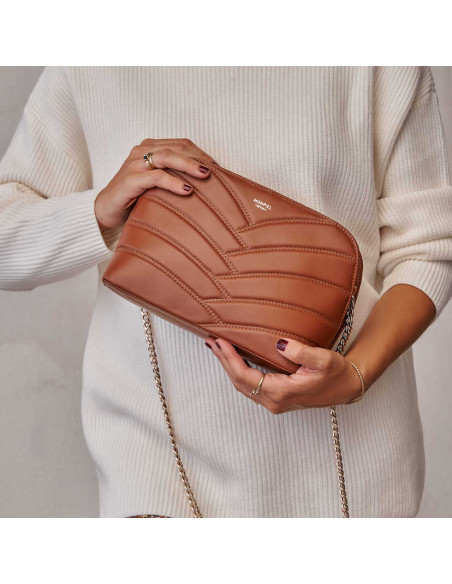 Tan quilted leather bag with gold chain, held in hands, tilted - MONPIEL