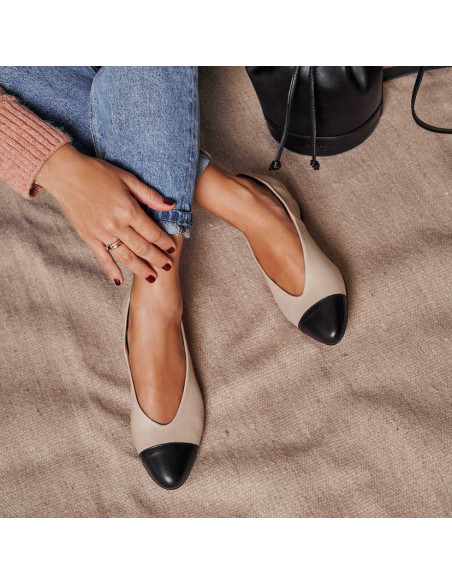 Ballerines à talons en cuir beige bicolore, jambes croisées sur un tapis à côté d’un sac - MONPIEL Ballerines à talons en cuir beige bicolore, jambes croisées sur un tapis à côté d’un sac - MONPIEL