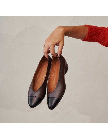 Ballerine in pelle bicolore marroni con tacco, tenute in mano - MONPIEL