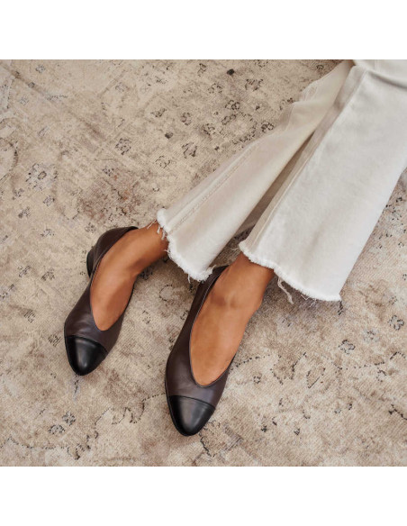 Ballerines à talons en cuir bicolore marron, jambes croisées sur un tapis - MONPIEL Ballerines à talons en cuir bicolore marron, jambes croisées sur un tapis - MONPIEL