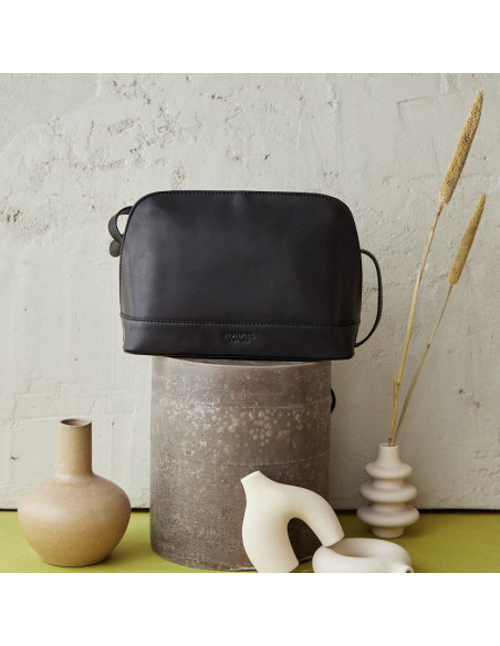Bolso mediano de piel en color negro con vista frontal encima de una vela - MONPIEL