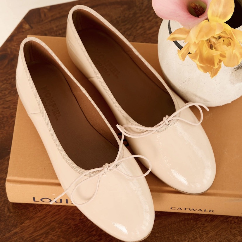 Nude patent leather high-heeled ballerina flats, top view, resting on a book - MONPIEL