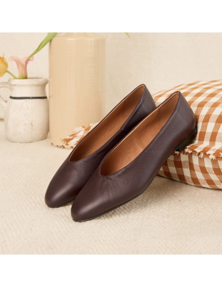 Burgundy flat ballerina, side view, resting on a cushion - MONPIEL Burgundy flat ballerina, side view, resting on a cushion - MONPIEL