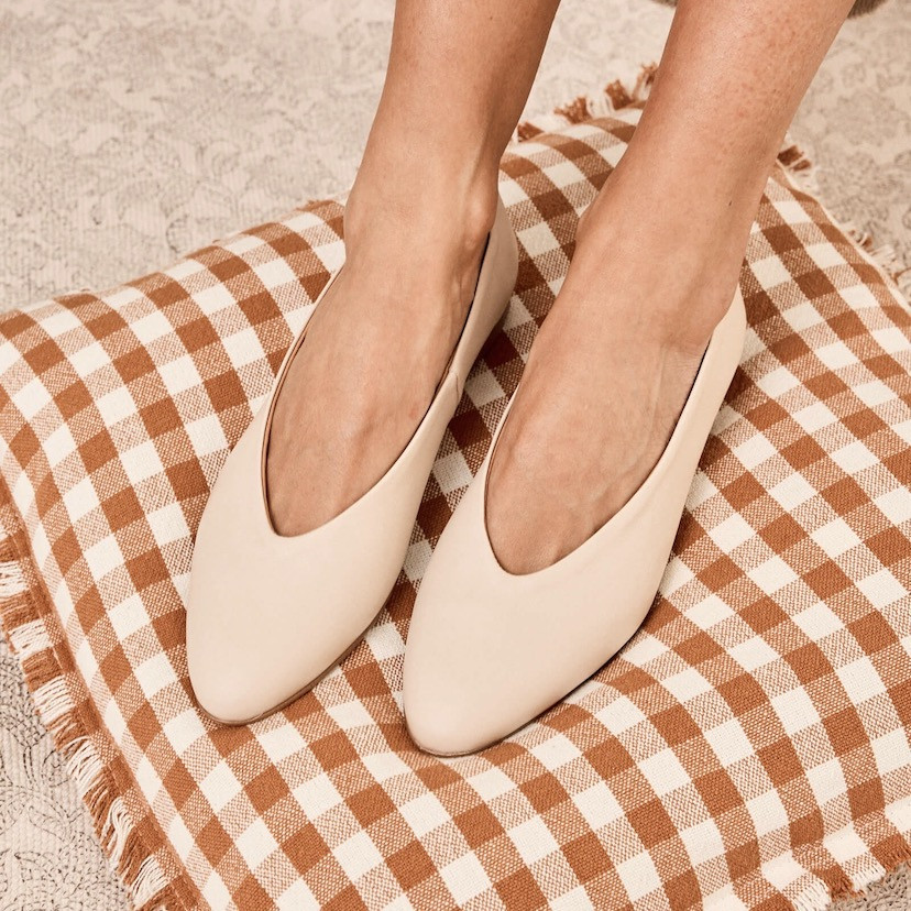 Beige flat ballerina, top view, worn on the feet, resting on a cushion - MONPIEL