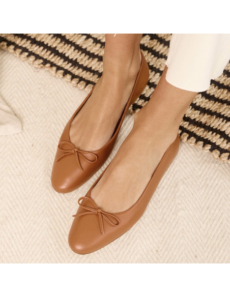 Leather Manolita pointed toe ballerina, top view, feet resting on a carpet - MONPIEL Leather Manolita pointed toe ballerina, top view, feet resting on a carpet - MONPIEL