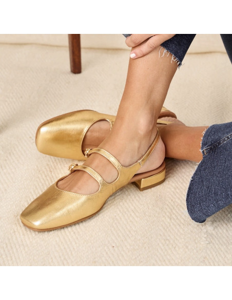 Gold Lolina backless Mary Janes, feet crossed on a carpet - MONPIEL