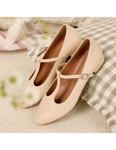 Beige leather women's Marieta Mary Janes, perspective view, heel resting on a cushion - MONPIEL Beige leather women's Marieta Mary Janes, perspective view, heel resting on a cushion - MONPIEL