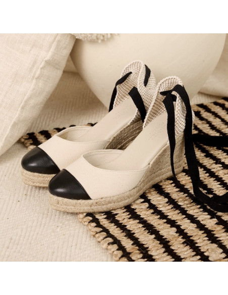 Espadrille compensée en cuir noir, vue en perspective sur tapis - MONPIEL Espadrille compensée en cuir noir, vue en perspective sur tapis - MONPIEL