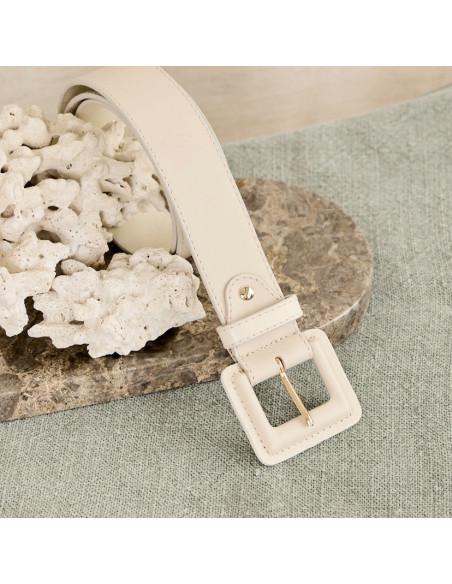 Women’s wide beige leather belt with covered buckle, coiled on marble with focus on buckle - MONPIEL Women’s wide beige leather belt with covered buckle, coiled on marble with focus on buckle - MONPIEL