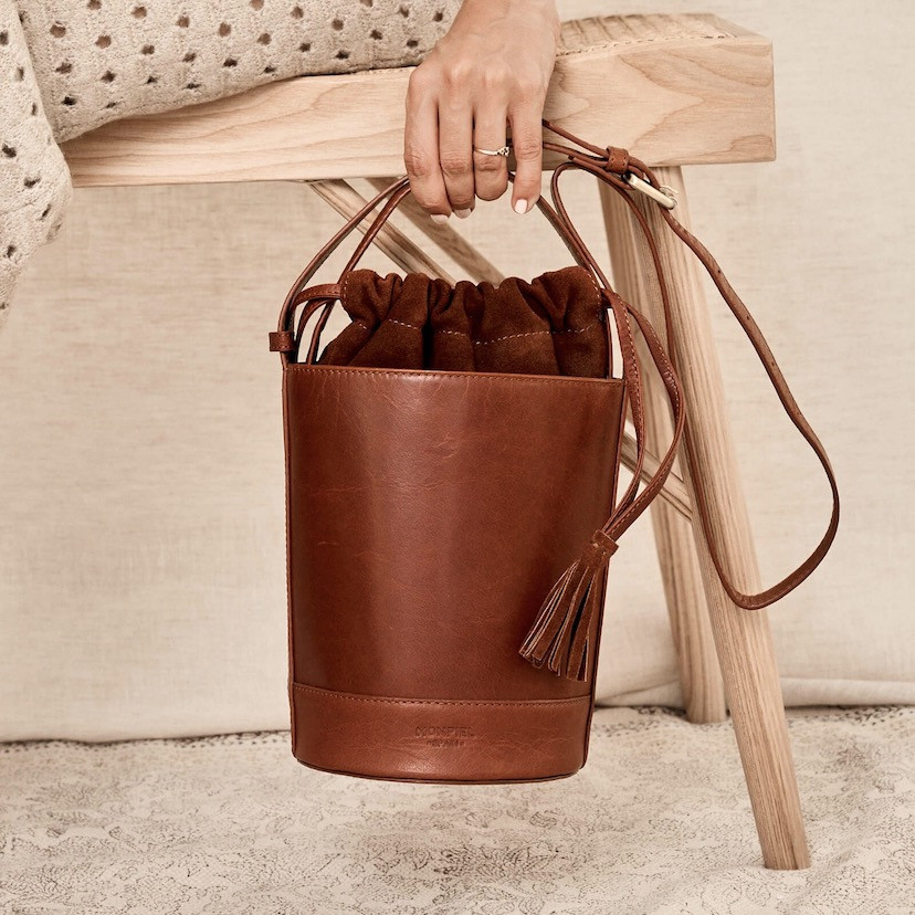 Small Havana leather round cube bag, front view, held by the short handle - MONPIEL