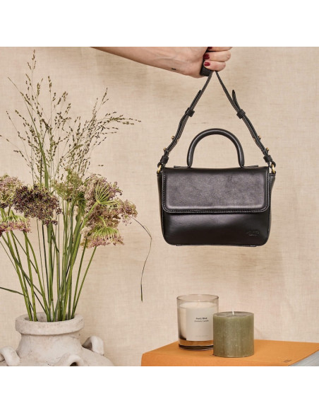 Petit sac structuré en cuir noir, vue frontale tenu par la longue poignée, détails de bougies - MONPIEL