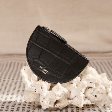 Leder-Münzgeldbörse in Halbmondform in Lederfarbe, gehalten in den Händen mit Außenhintergrund - MONPIEL 2