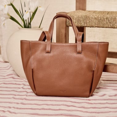 Bolso canasto piel en color topo apoyado en el sofa con vista frontal - MONPIEL 2