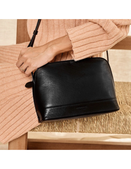 Sac moyen en cuir noir, vue de face, suspendu à l'épaule au-dessus d'une chaise - MONPIEL