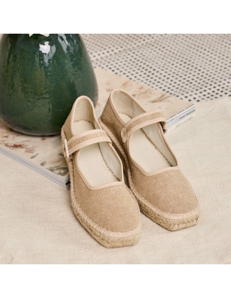 Espadrilha Mary Jane Cuba em bege com brilho, vista em perspectiva, apoiada sobre revista - MONPIEL Espadrilha Mary Jane Cuba em bege com brilho, vista em perspectiva, apoiada sobre revista - MONPIEL