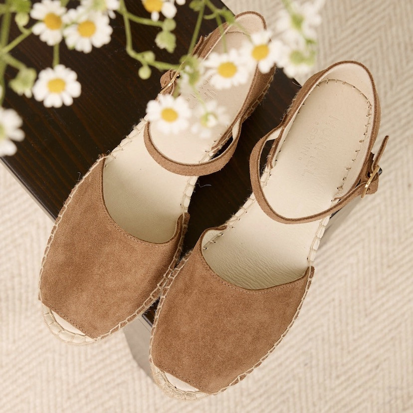 Mink-colored mid-wedge menorca espadrille, top view, blurred flowers in the background - MONPIEL