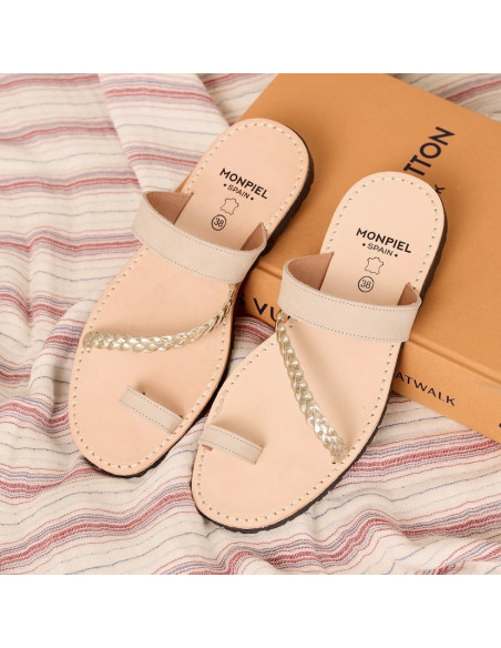 Icy-colored Mykonos Greek leather sandal, front perspective view, resting on a book - MONPIEL Icy-colored Mykonos Greek leather sandal, front perspective view, resting on a book - MONPIEL