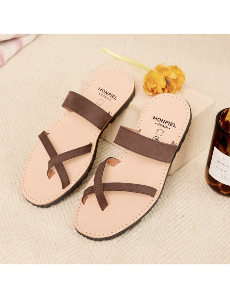 Sandales en cuir style grec Santorini couleur marron, vue en perspective avec le talon reposant sur une pierre - MONPIEL